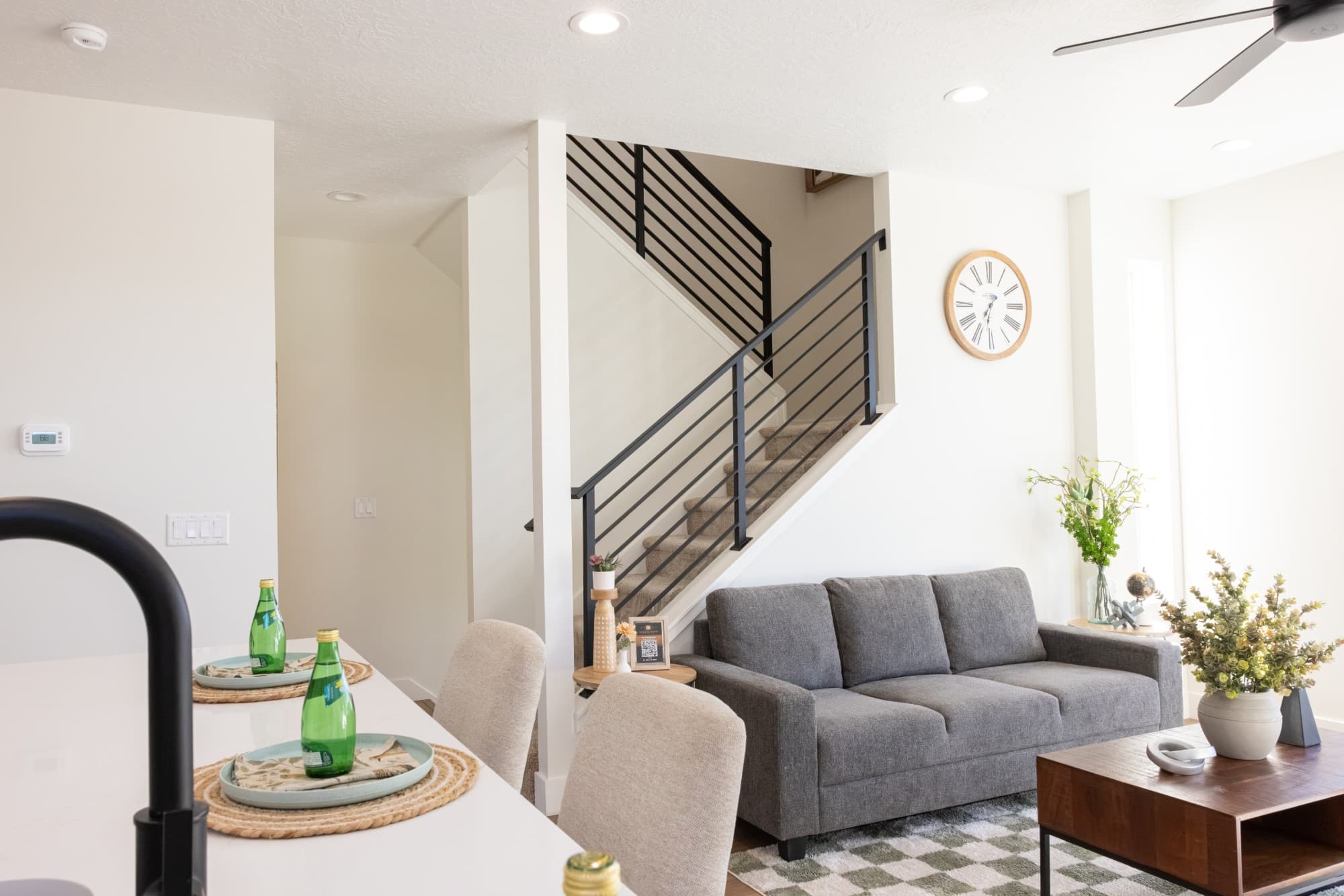 Open living room and kitchen island with a modern railed staircase